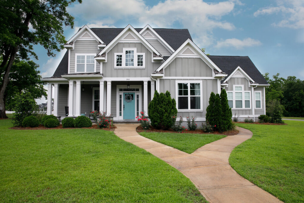 hip roof vs gable roof-large home with gable roofing and dark gray shingles