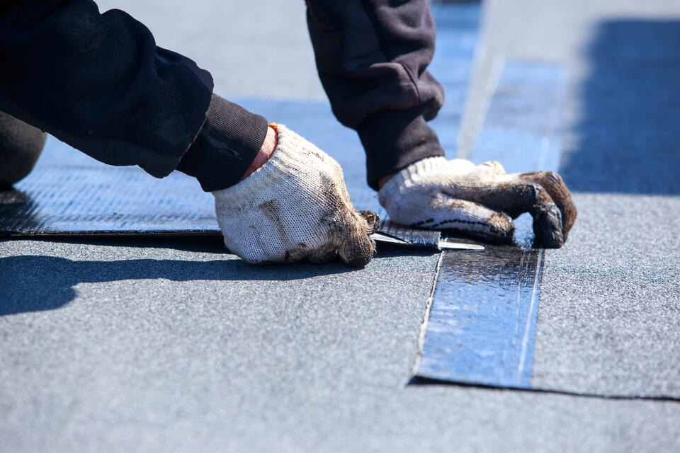 modified bitumen roofing-close up view of a tech installing flat roof materials