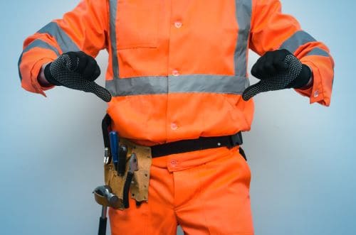 Professional roofer in orange safety gear with tools, specializing in roofing and construction services.