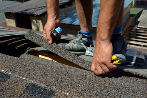 Shamrock roofing construction worker installing asphalt shingle roof, roofing repair service.