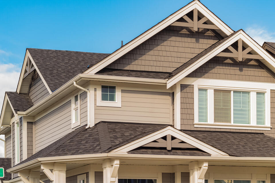 light brown sided house with dark brown shingled roof