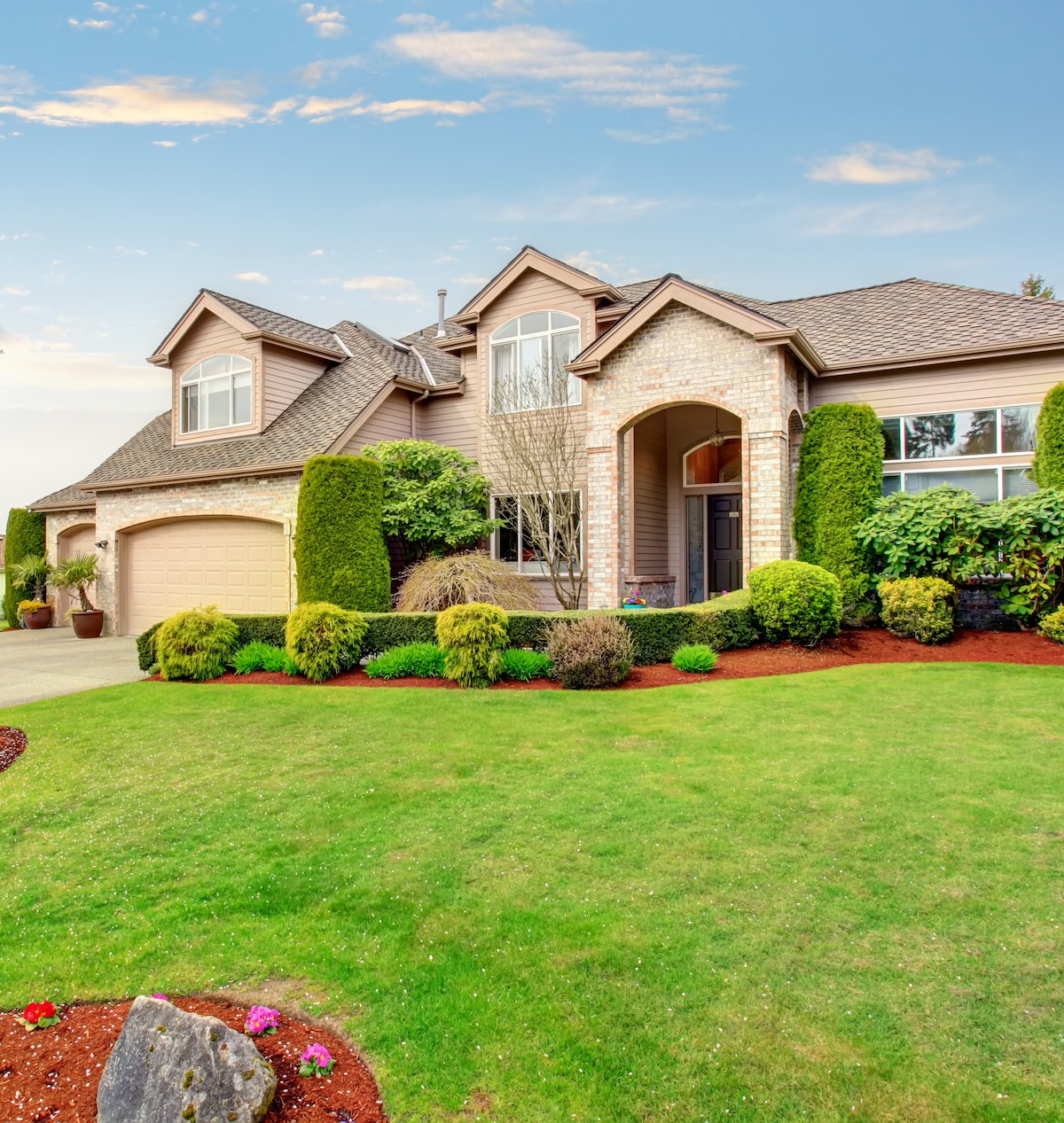 Luxurious raytown missouri home with greenery, garage, and driveway.