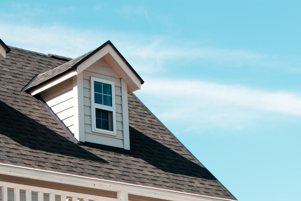 roofing farmington ar-white sided house with dark gray shingled roof