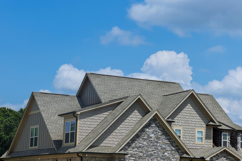 roofing lowell ar-gray stone sided house with dark gray shingled roof