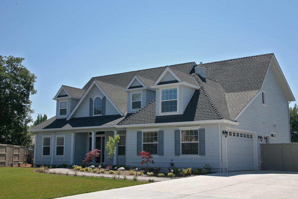 roofing o'fallon mo-white house with blue shutters and gray shingled roof