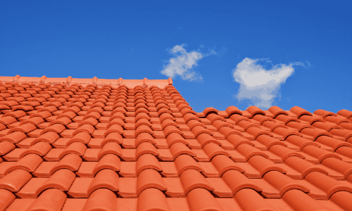 Clay tile roof under blue sky, durable roofing and construction services, Shamrock Roofing and Construction.