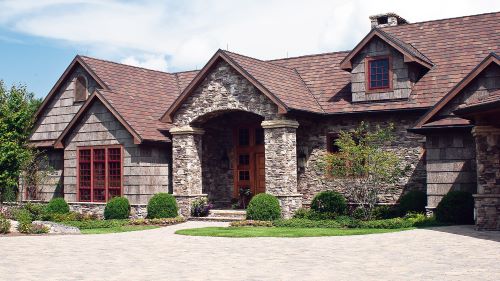 Shamrock Roofing and Construction custom home exterior with durable roofing and stone accents in a residential setting.