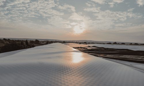 Metal roof in sunset with beautiful sky, durable roofing, Shamrock Roofing and Construction.