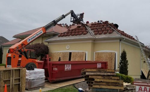 Shamrock Roofing and Construction repairing roof with crane and safety equipment.