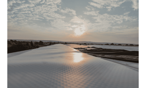 Galvanized metal roof reflecting sunset, durable roofing materials, Shamrock Roofing and Construction.