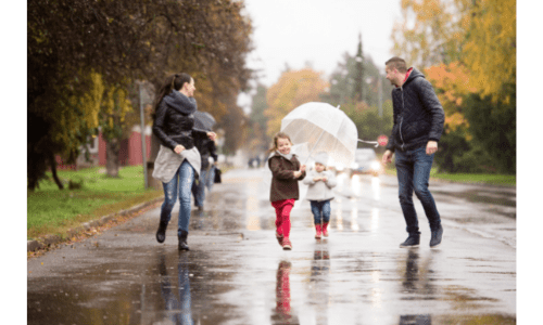family playing in the rain