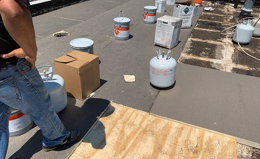 Heavy-duty roofing supplies and equipment on a flat rooftop for a residential or commercial roof replacement.