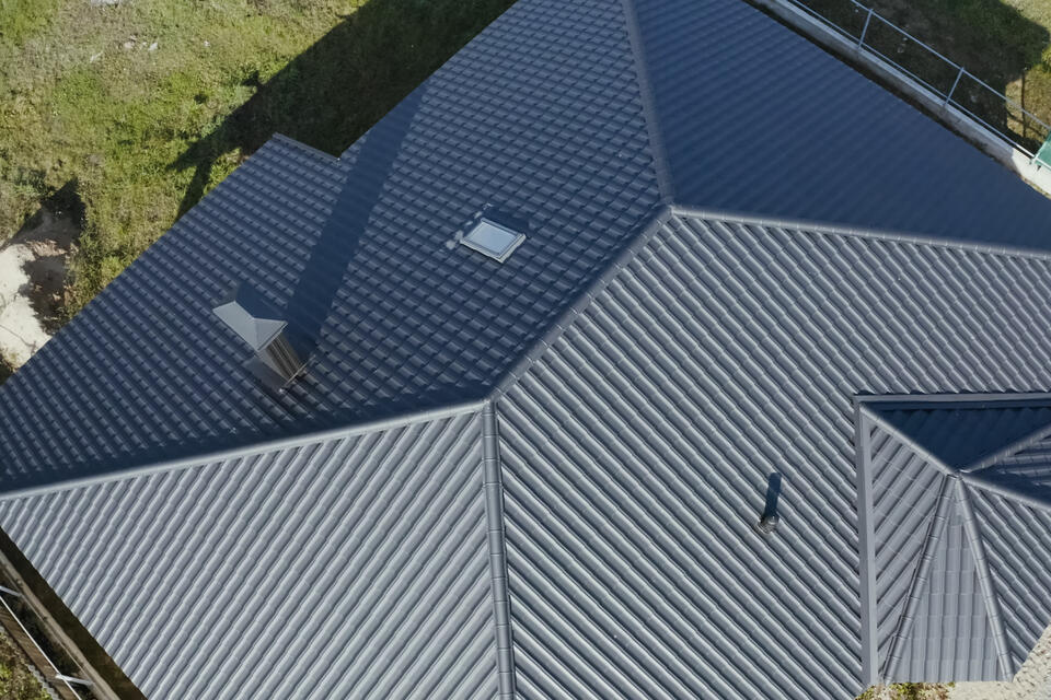 benefits of metal roofing-aerial view of a roof with black metal roofing