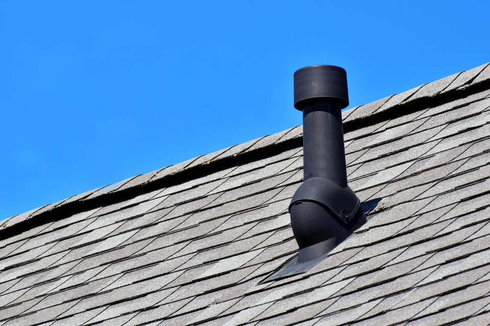 types of roof vents-black pipe vent on a gray shingle roof