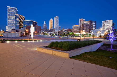 Downtown skyline with modern buildings and city park at night.