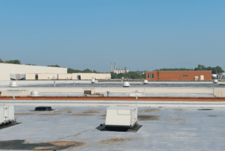 Aerial view of industrial building rooftop with roofing materials in place.