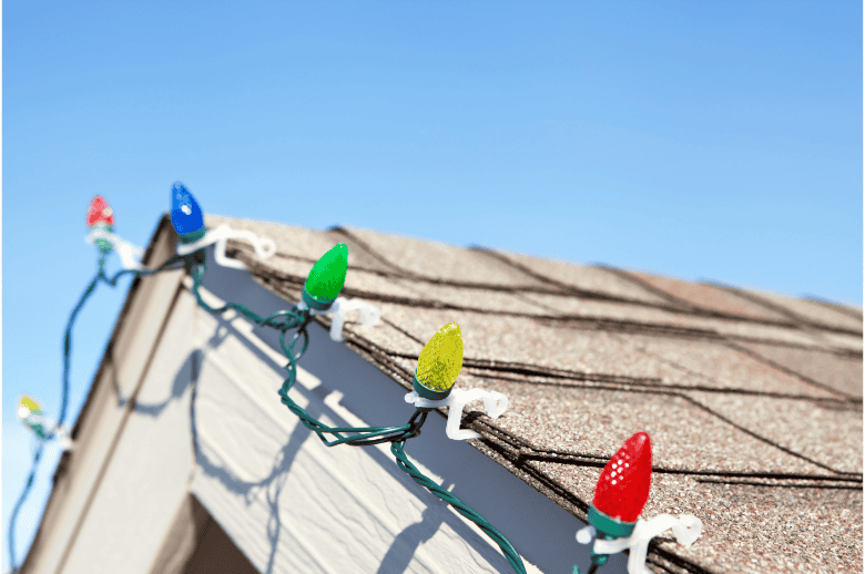 Colorful holiday string lights on a residential roof - Shamrock Roofing and Construction.