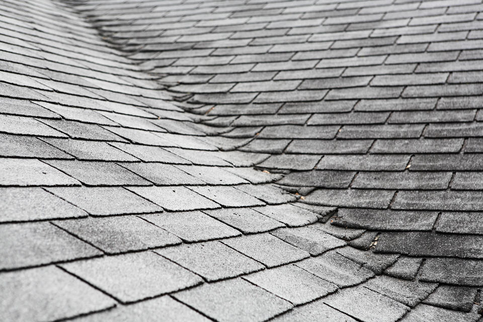 hail damage vs blistering-close up of roof with damaged and aging shingles