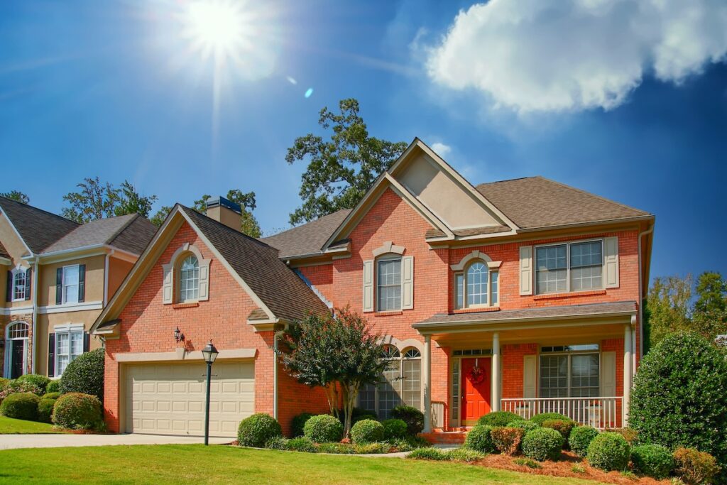 A nice brick home in lenexa ks on a grassy lot with a red door