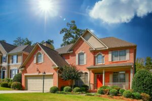 A nice brick home in lenexa ks on a grassy lot with a red door