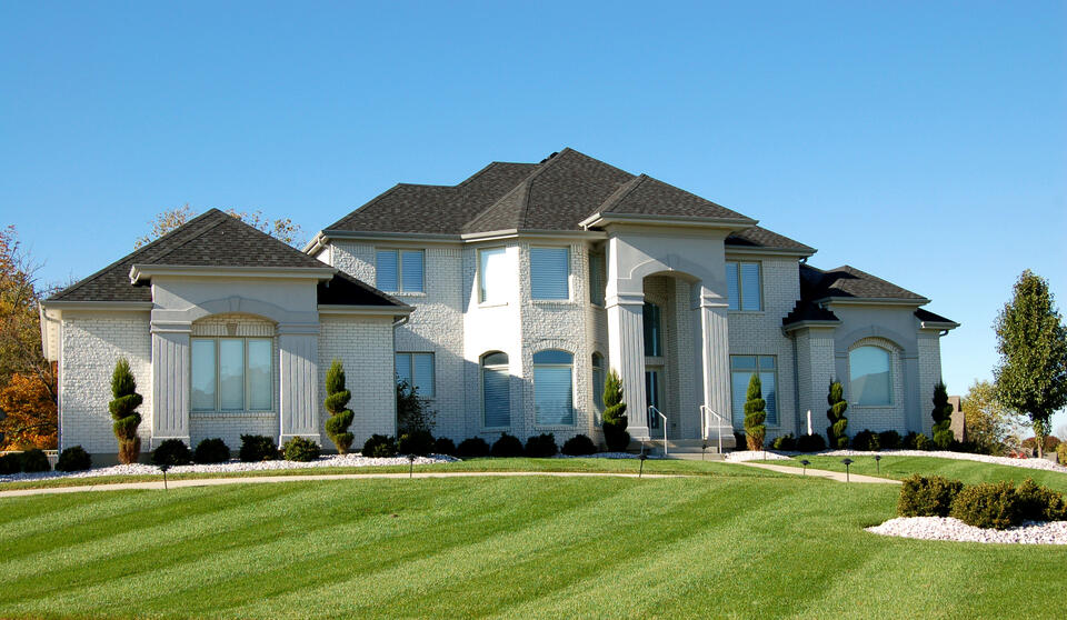 hip roof vs gable roof-large home with hip roof and dark gray shingles