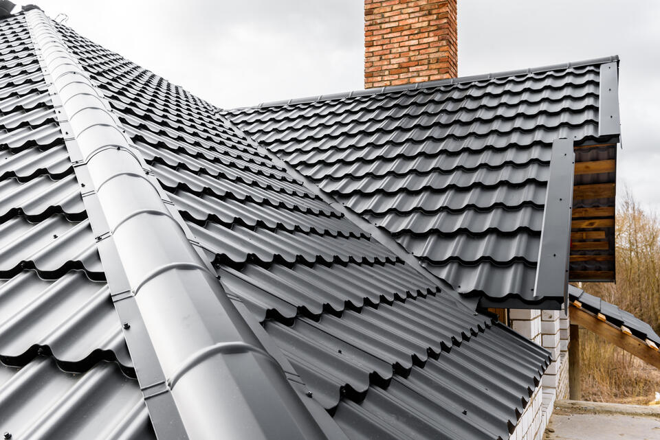 metal roofing types-close up view of black metal shingle roofing on a house