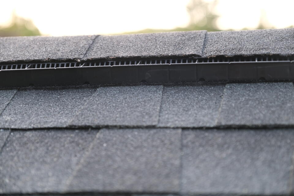 roof ridge cap-close up view of ventilated roof ridge cap on shingled roof