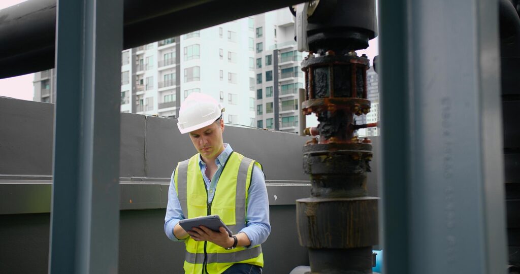 commercial roof inspection-roofer in safety gear inspecting commercial roof