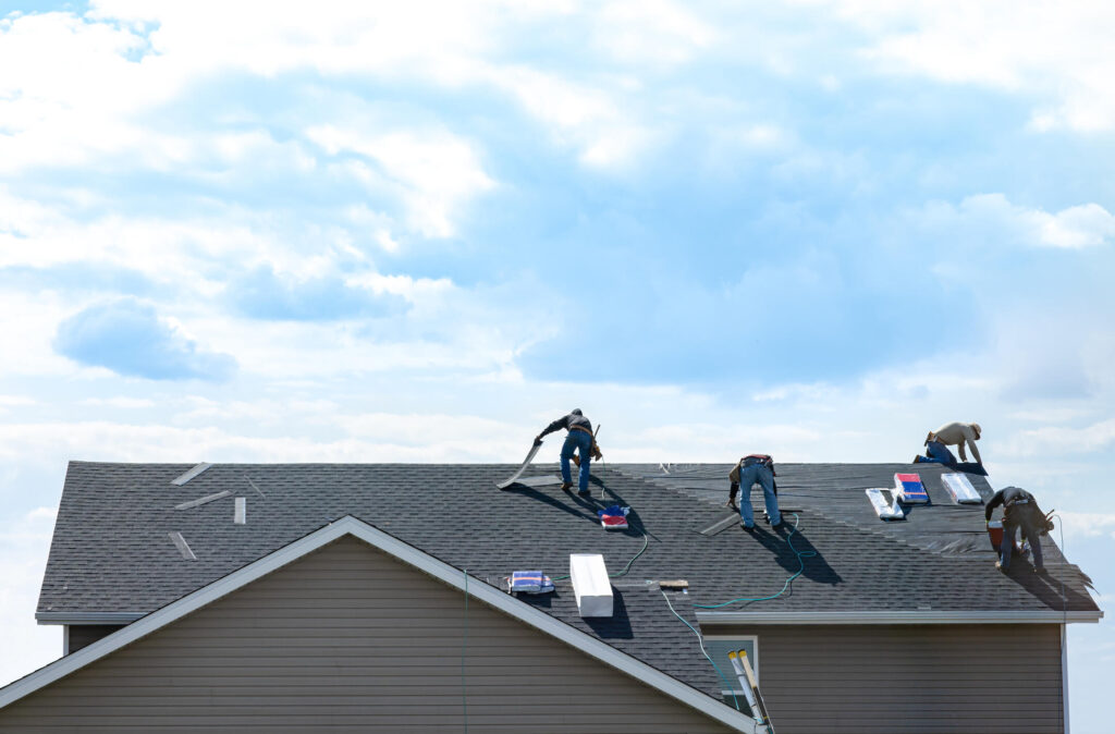 how long does it take to replace a roof-distant view of a team of roofers replacing shingle roof