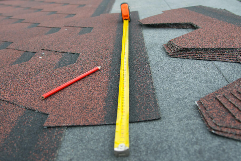 how to measure a roof for shingles-close up of shingles and a measuring tape