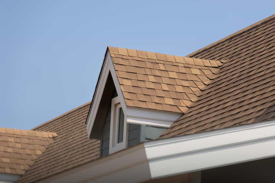 metal roof vs shingles cost-close up of brown shingles on a house roof