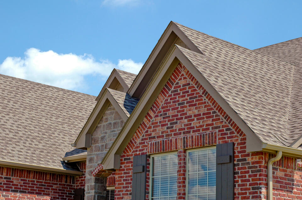 VernCo roofing-red brick house with gray shingle roof